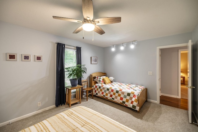 carpeted bedroom featuring a ceiling fan, baseboards, and track lighting