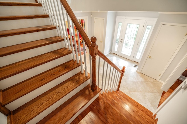 stairs featuring baseboards, visible vents, and tile patterned flooring