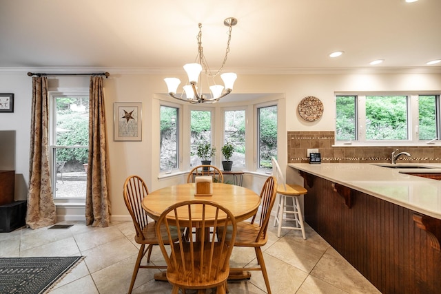 dining area featuring crown molding, plenty of natural light, light tile patterned flooring, and a chandelier