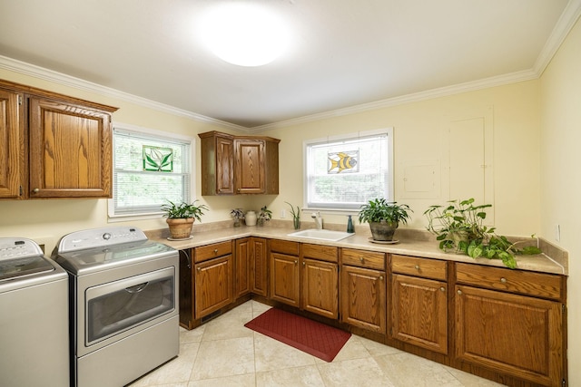 clothes washing area with washing machine and clothes dryer, crown molding, cabinet space, a sink, and light tile patterned floors