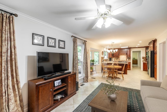 living area with visible vents, ornamental molding, ceiling fan with notable chandelier, and light tile patterned floors