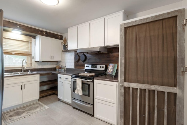 kitchen featuring dark countertops, stainless steel electric range, white cabinetry, under cabinet range hood, and a sink