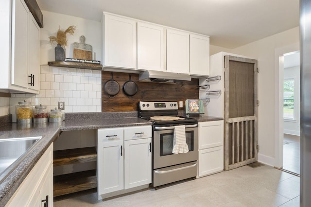 kitchen with stainless steel range with electric stovetop, dark countertops, white cabinetry, under cabinet range hood, and backsplash