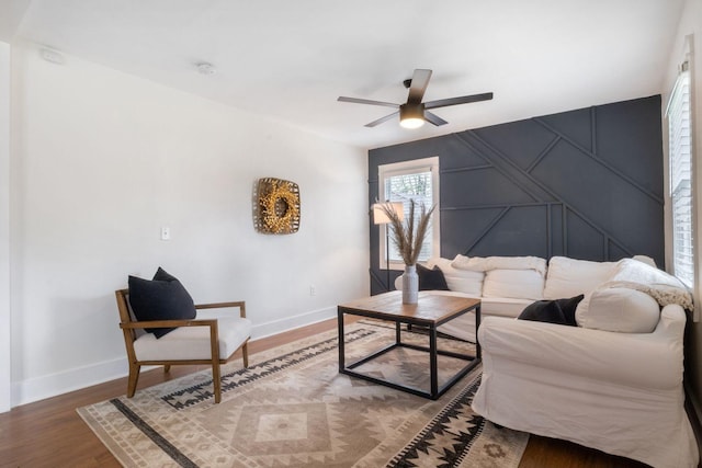 living area with ceiling fan, baseboards, and wood finished floors