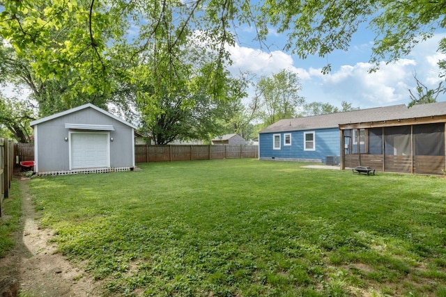 view of yard featuring central AC unit, an outbuilding, a sunroom, a fenced backyard, and a storage unit