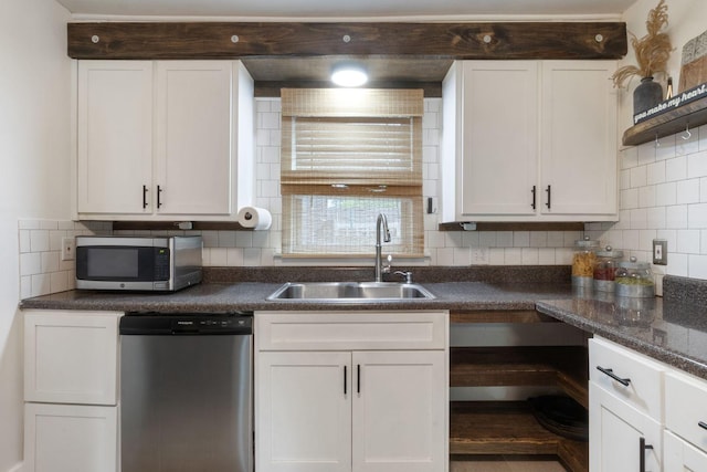 kitchen featuring a sink, white cabinets, dark countertops, and stainless steel appliances