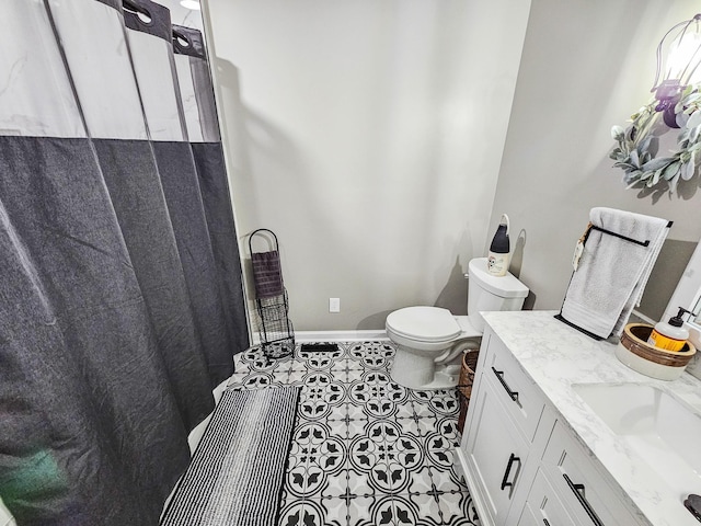 full bath featuring vanity, tile patterned flooring, baseboards, and toilet