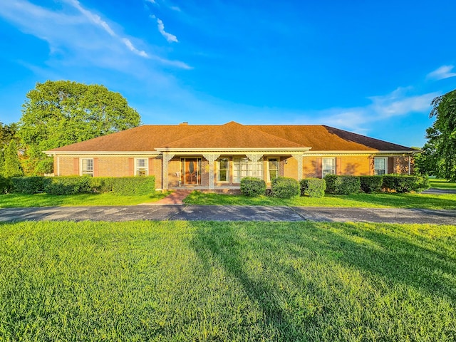 ranch-style home featuring brick siding and a front lawn