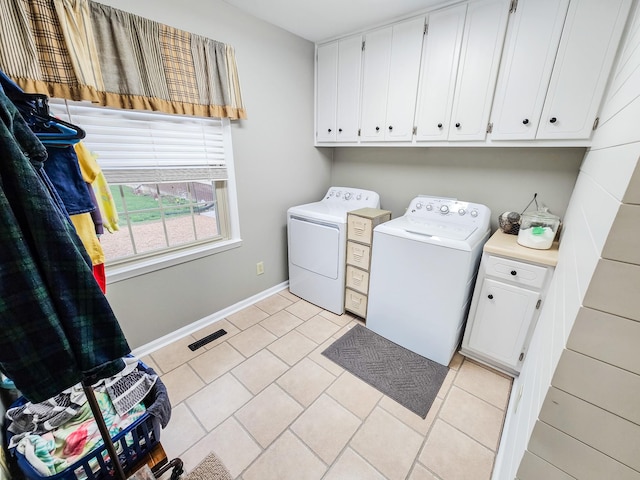 laundry room featuring visible vents, baseboards, washing machine and clothes dryer, cabinet space, and light tile patterned floors