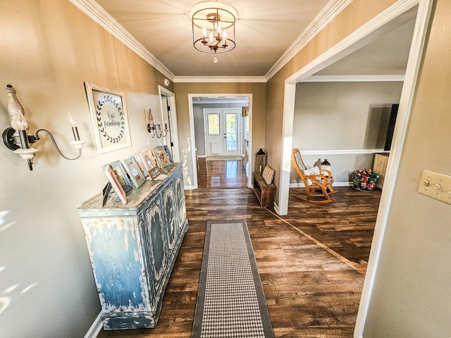 corridor with baseboards, dark wood finished floors, ornamental molding, and an inviting chandelier