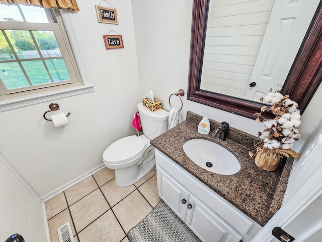 bathroom with toilet, baseboards, tile patterned flooring, and vanity