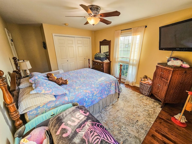 bedroom with baseboards, ceiling fan, a closet, and wood finished floors