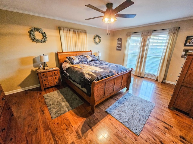 bedroom featuring crown molding, a ceiling fan, baseboards, and wood finished floors