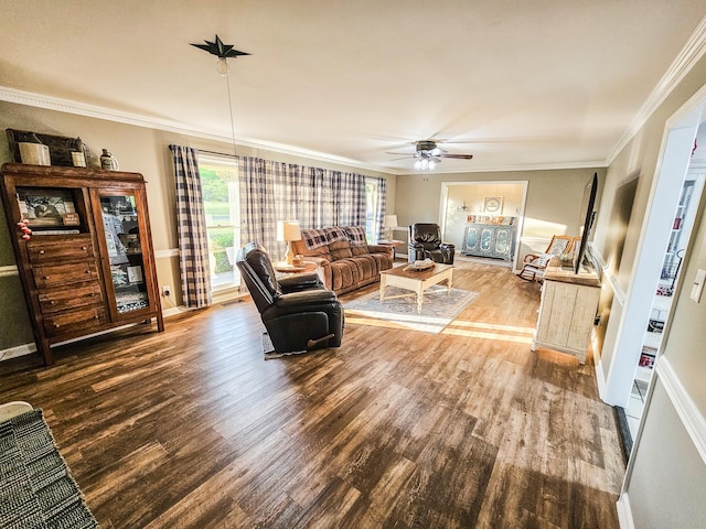living area with baseboards, ceiling fan, ornamental molding, and wood finished floors