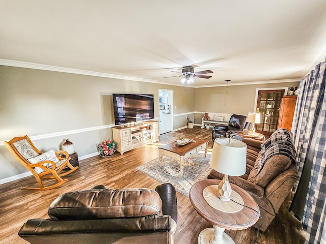 living area with baseboards, crown molding, ceiling fan, and wood finished floors