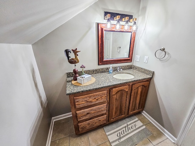 bathroom featuring lofted ceiling, tile patterned flooring, and vanity