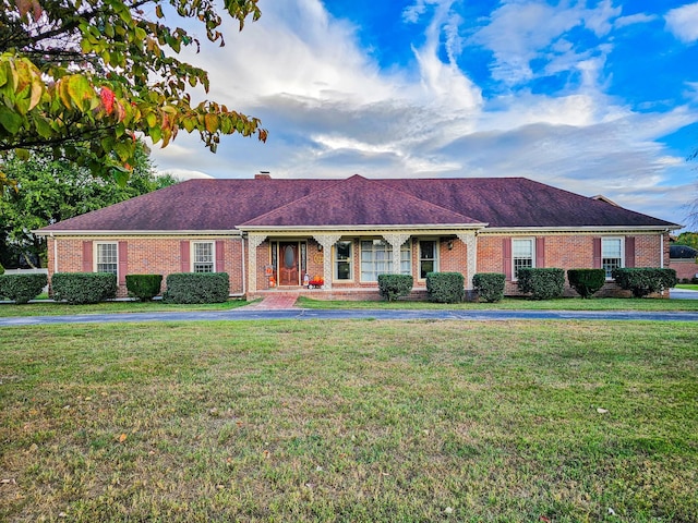 ranch-style home featuring a front yard and brick siding