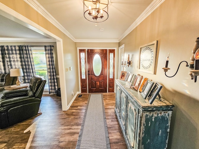 foyer featuring an inviting chandelier, ornamental molding, baseboards, and dark wood-style floors