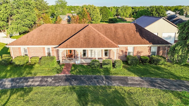 view of front of house featuring brick siding, a chimney, and a front lawn