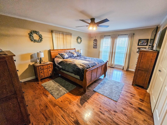 bedroom featuring crown molding, a ceiling fan, baseboards, and wood finished floors