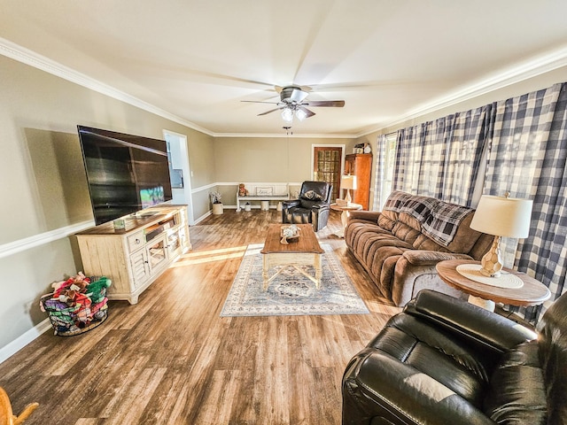 living room with baseboards, a ceiling fan, wood finished floors, and ornamental molding
