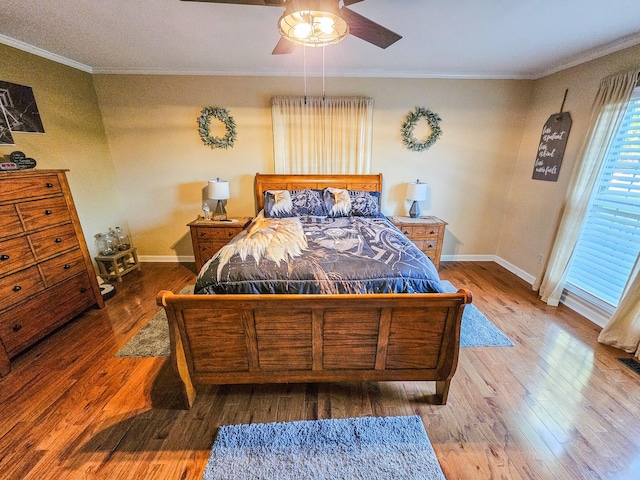 bedroom featuring crown molding, a ceiling fan, baseboards, and wood finished floors