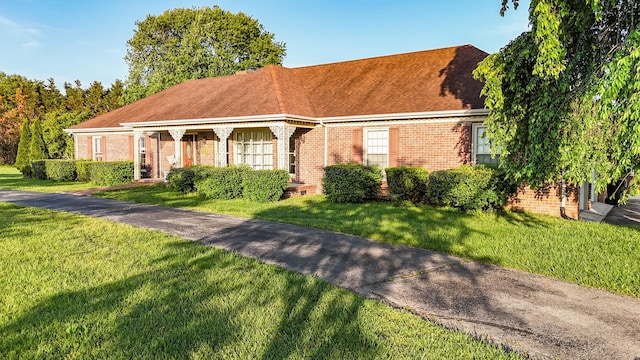 view of front of house featuring brick siding and a front lawn