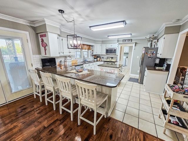 kitchen with crown molding, appliances with stainless steel finishes, decorative backsplash, and a peninsula