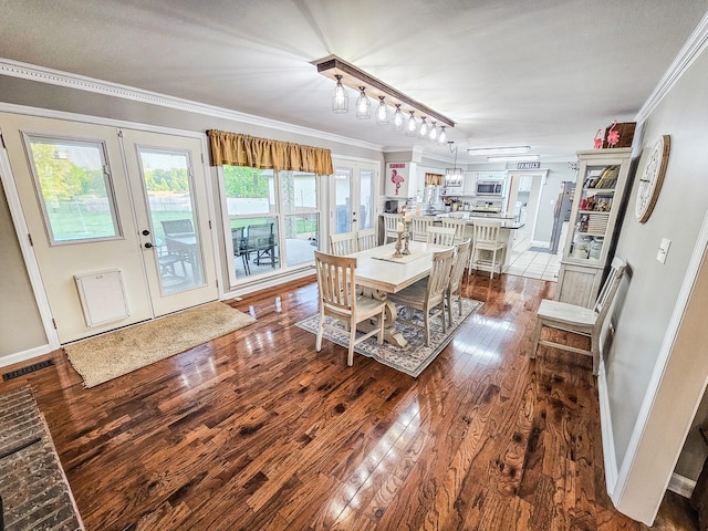 dining area featuring crown molding, dark wood-style flooring, visible vents, and french doors