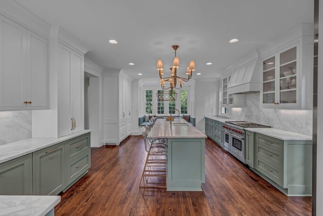 kitchen featuring an inviting chandelier, tasteful backsplash, custom exhaust hood, glass insert cabinets, and green cabinets