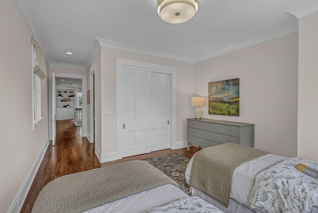 bedroom with baseboards, ornamental molding, a closet, and dark wood-type flooring