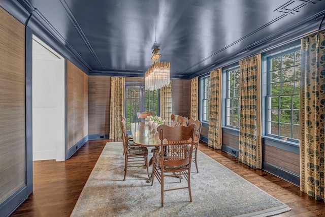 dining area with an inviting chandelier, ornamental molding, baseboards, and wood finished floors