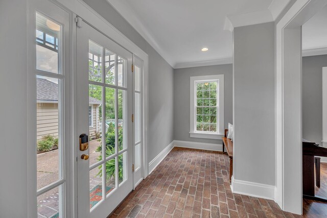 entryway featuring recessed lighting, baseboards, a wealth of natural light, and brick floor