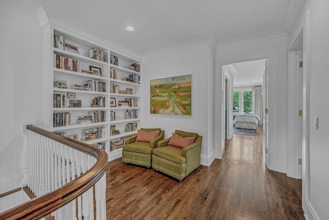living area featuring crown molding, baseboards, built in features, and wood finished floors