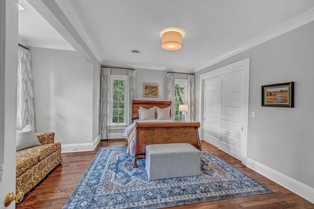 bedroom with crown molding, baseboards, and wood finished floors