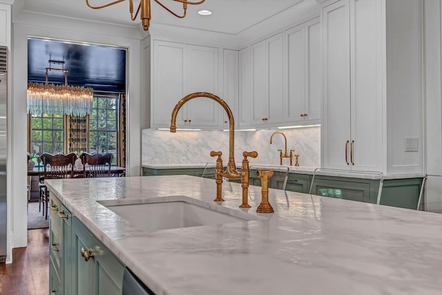 kitchen featuring recessed lighting, green cabinetry, an inviting chandelier, and a sink
