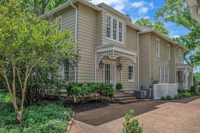 traditional home featuring central AC unit and a chimney
