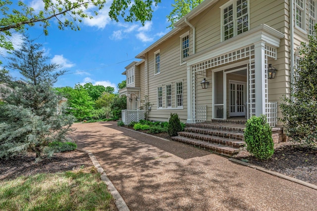view of side of property featuring a porch and driveway