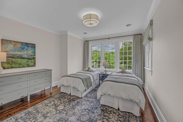 bedroom featuring crown molding, baseboards, and wood finished floors