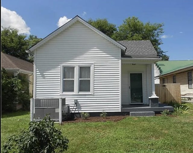 back of house featuring fence and a yard