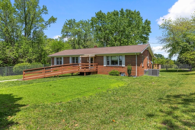 1759 Summertown Hwy, Hohenwald, TN 38462 - back of house with fence, brick siding, a deck, a chimney, and a lawn