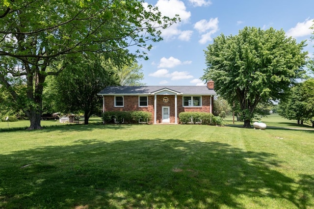 view of front facade featuring brick siding, a front lawn, and a chimney