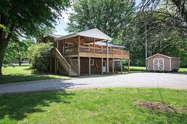 view of front facade featuring a front lawn, brick siding, a deck, a shed, and an outdoor structure