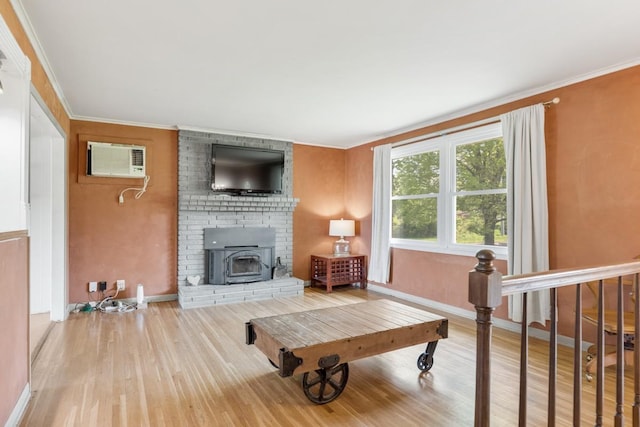 living area with baseboards, a wall mounted AC, ornamental molding, and wood finished floors