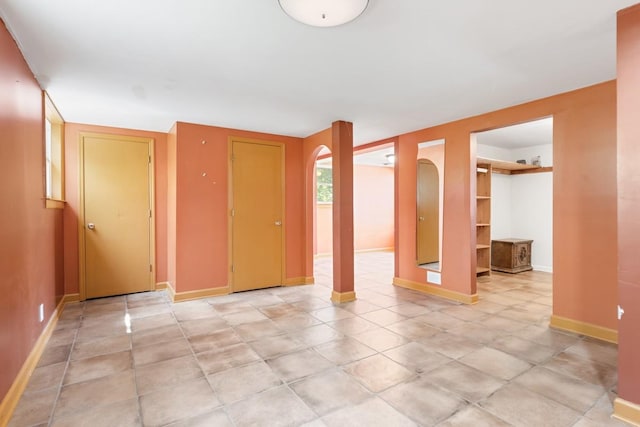interior space featuring baseboards and arched walkways