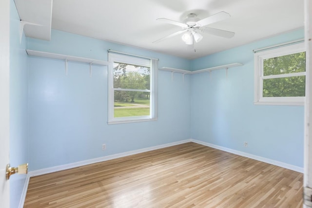empty room featuring baseboards, ceiling fan, and light wood-style flooring