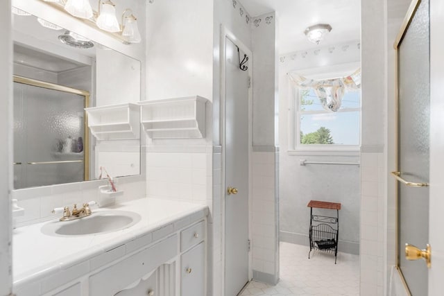 bathroom with a shower with shower door and vanity