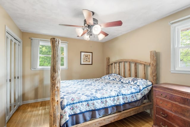 bedroom with a ceiling fan, baseboards, wood finished floors, and a closet