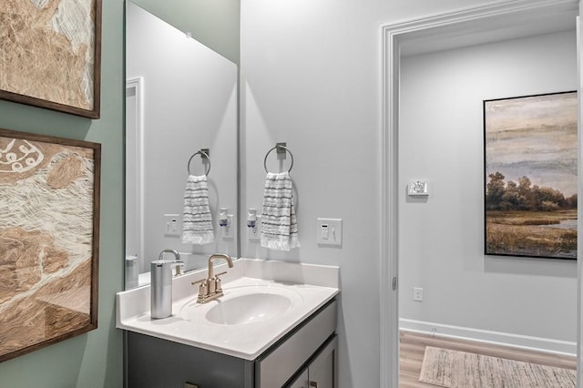 bathroom with vanity, baseboards, and wood finished floors