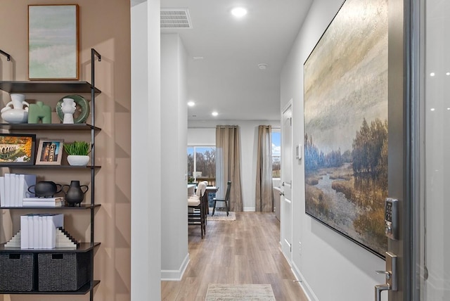 hall with baseboards, recessed lighting, wood finished floors, and visible vents